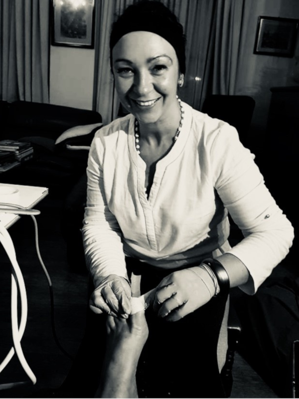 Zwart-wit foto van Chantal zittend in een interieur, glimlachend in een lichte blouse